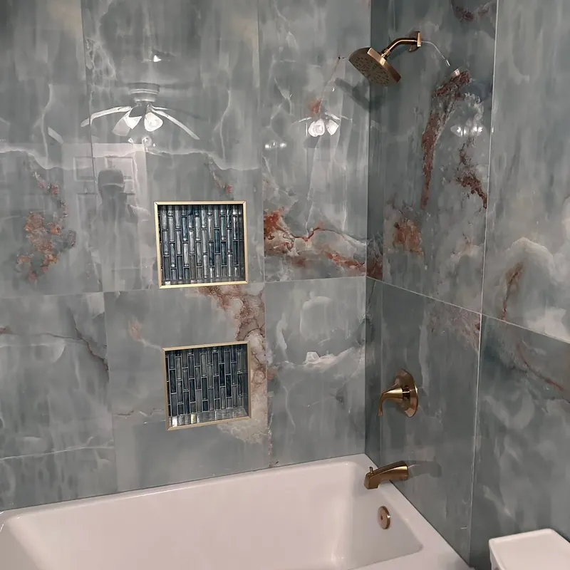 Blue onyx tile tub-shower with niches and brass fixtures, C&A Roofing & Construction