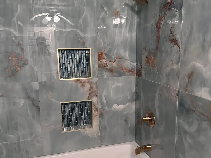 Blue onyx tile tub-shower with niches and brass fixtures, C&A Roofing & Construction