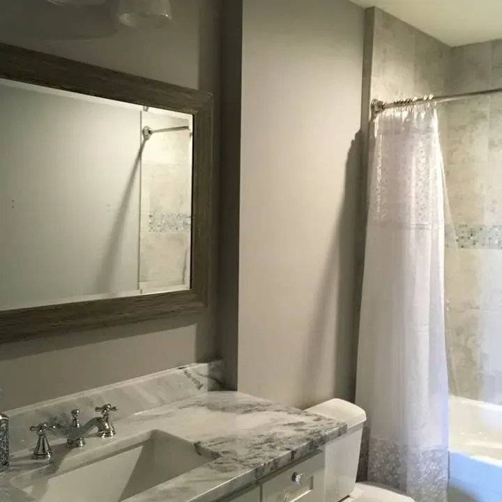 Vanity with marble top, toilet, and curtain shower, C&A Roofing & Construction