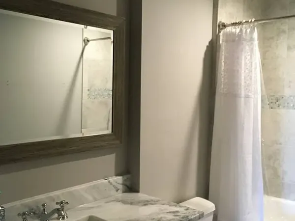 Vanity with marble top, toilet, and curtain shower, C&A Roofing & Construction