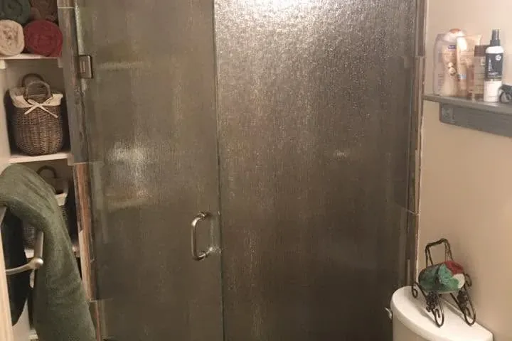 Corner glass shower with wood-look tile and vanity, C&A Roofing & Construction