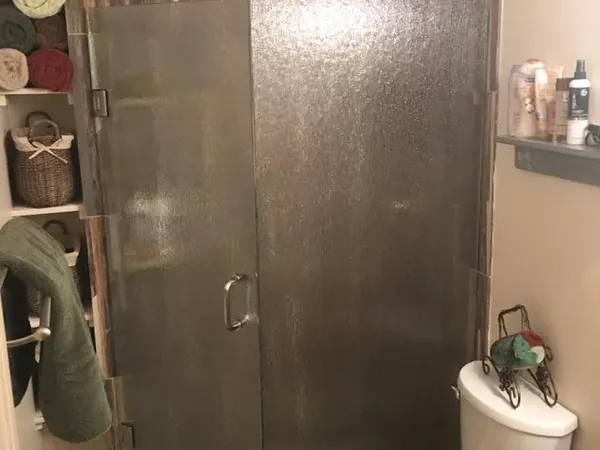 Corner glass shower with wood-look tile and vanity, C&A Roofing & Construction