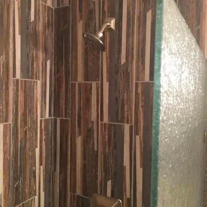 Close-up of wood-look tile shower wall and glass, C&A Roofing & Construction