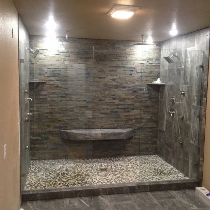 Large walk-in shower with stone tile and pebble floor, C&A Roofing & Construction