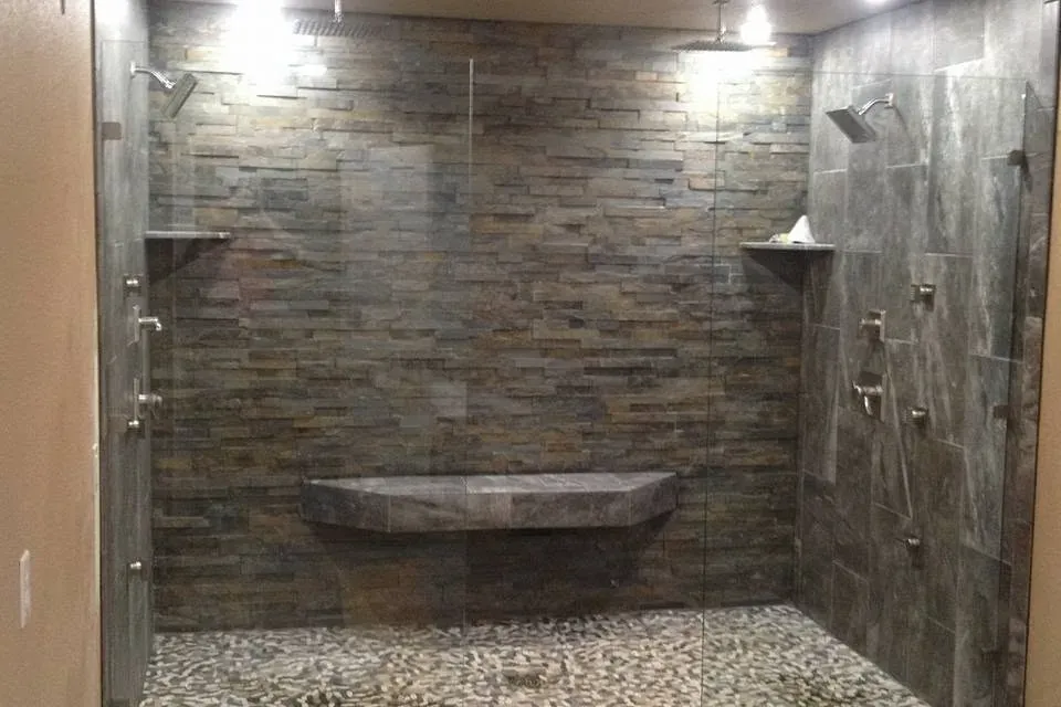 Large walk-in shower with stone tile and pebble floor, C&A Roofing & Construction
