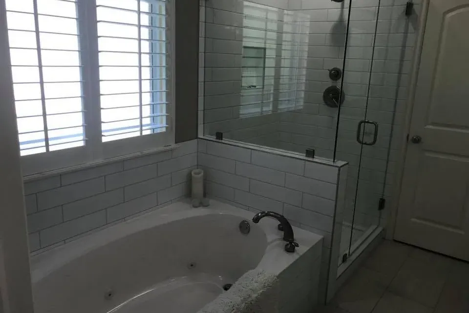 White subway tile tub surround, jetted tub, glass shower, C&A Roofing & Construction