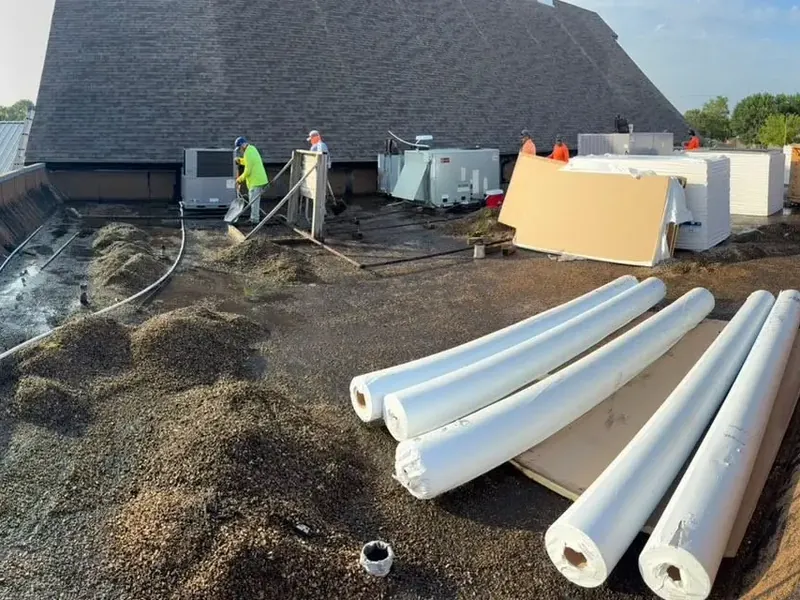 Flat roof tear-off with insulation rolls and crew, C&A Roofing & Construction