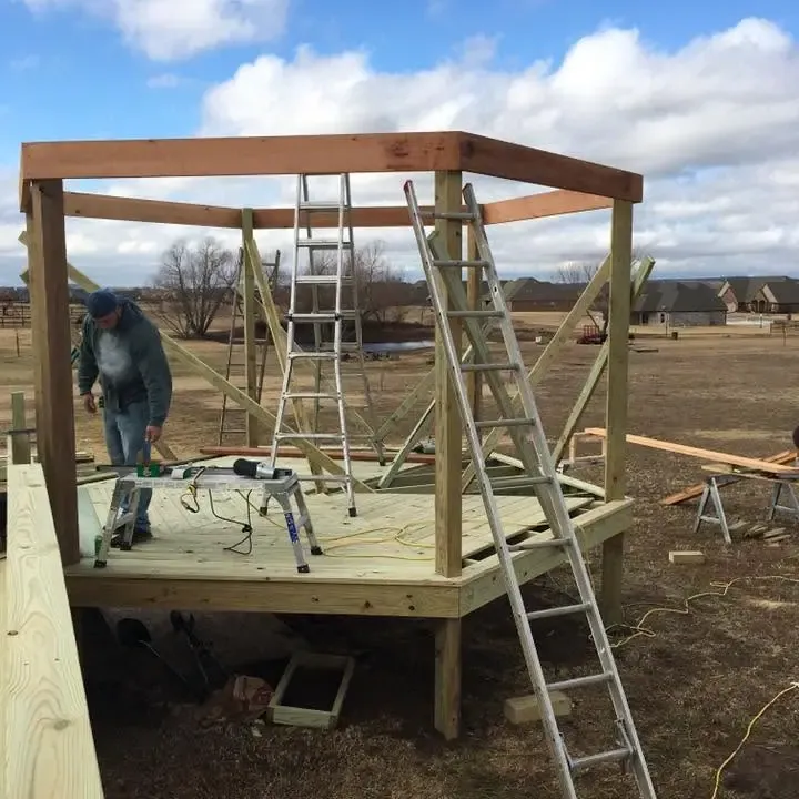 Worker building wooden pergola frame on new deck, C&A Roofing & Construction