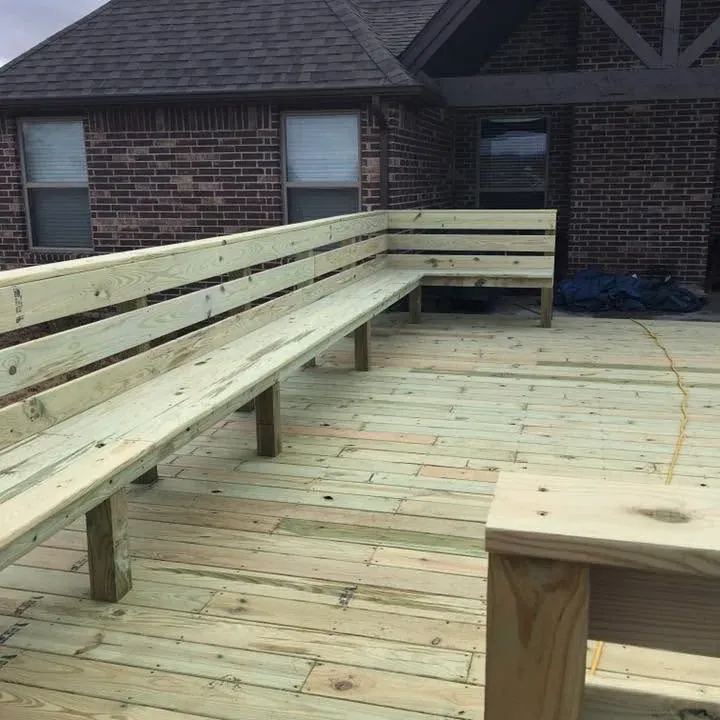 New wood deck with long built-in benches by brick house, C&A Roofing & Construction