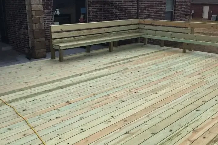New wood deck with built-in bench behind brick house, C&A Roofing & Construction