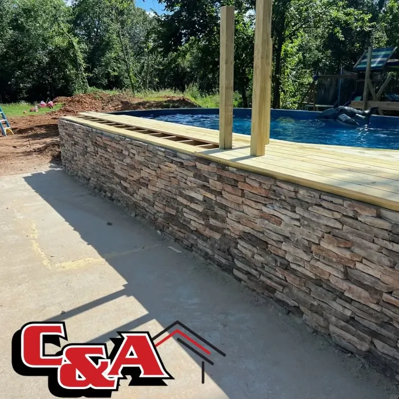 Stacked stone wall and wood deck around pool, C&A Roofing & Construction