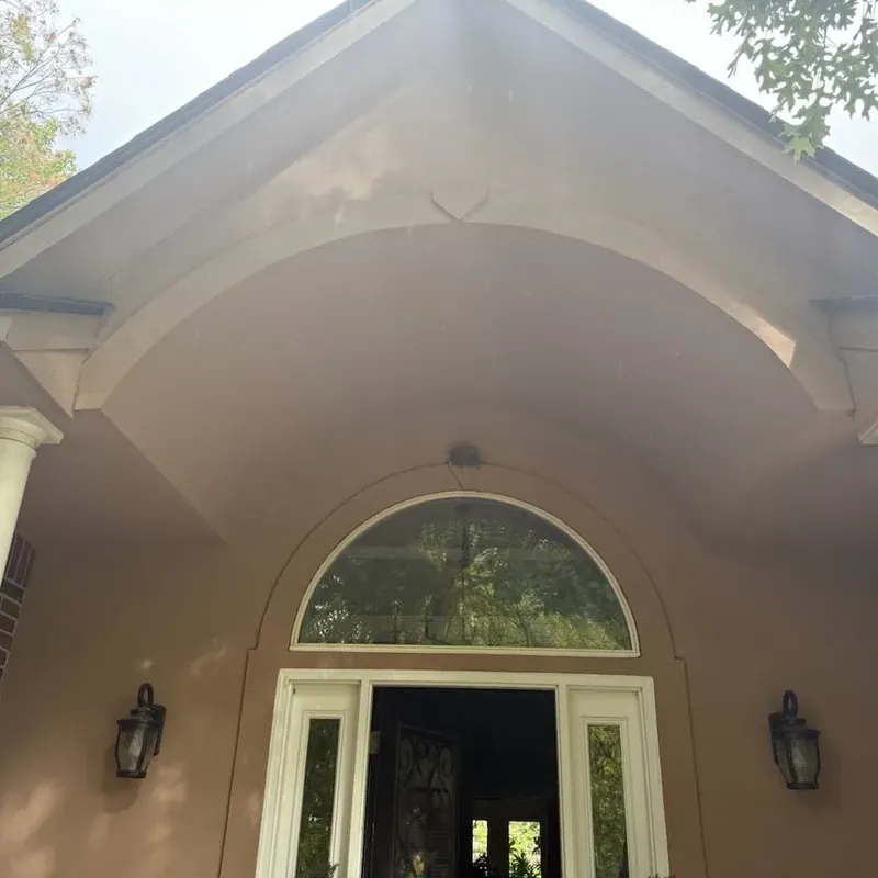 Painted stucco entry gable with archway and columns, C&A Roofing & Construction