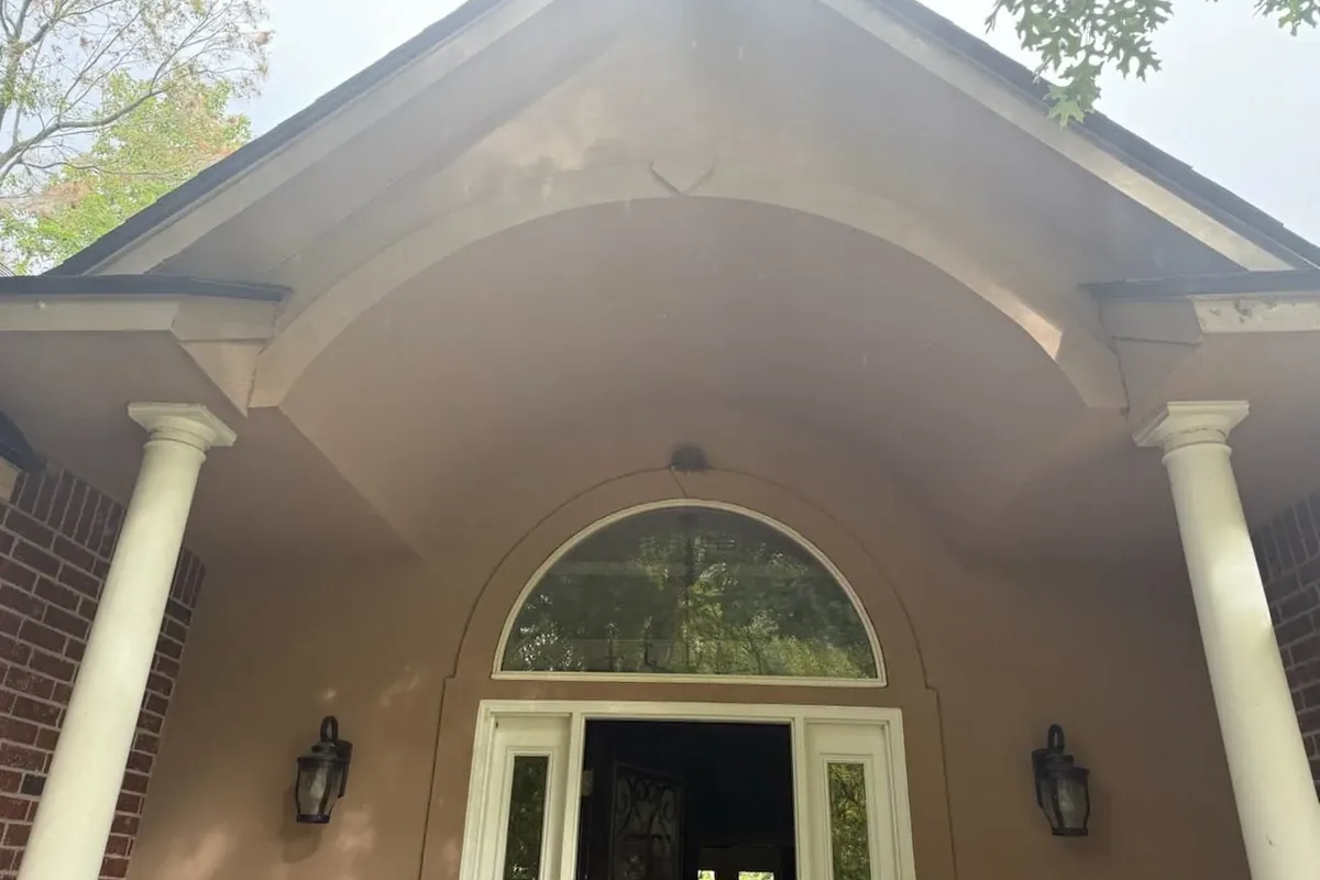 Painted stucco entry gable with archway and columns, C&A Roofing & Construction