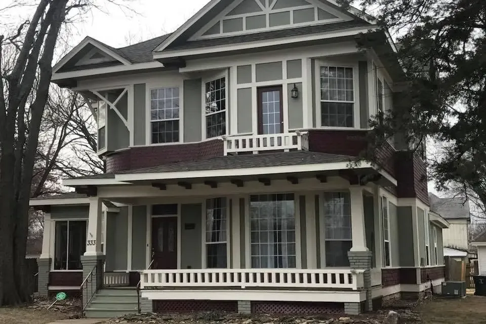 Repainted two-story Victorian house with porch, C&A Roofing & Construction