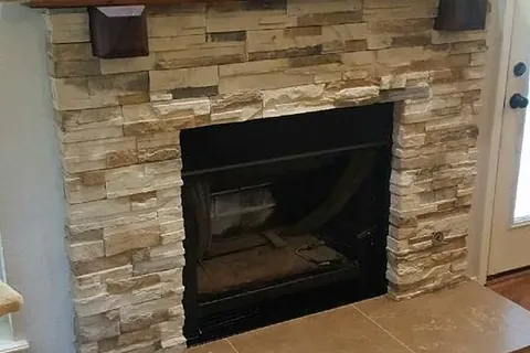 Stone veneer fireplace with wood mantel and tile hearth, C&A Roofing & Construction