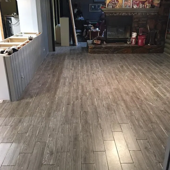 Newly installed wood-look tile in open living area, C&A Roofing & Construction