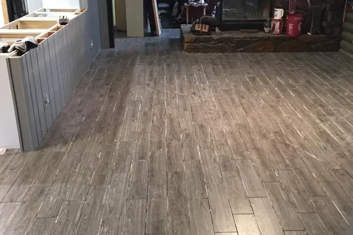 Newly installed wood-look tile in open living area, C&A Roofing & Construction