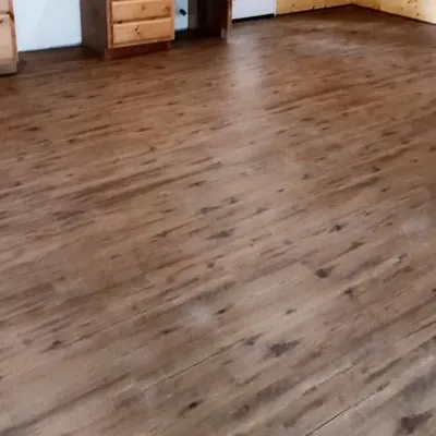 Finished wood laminate floor in open room with cabinets, C&A Roofing & Construction
