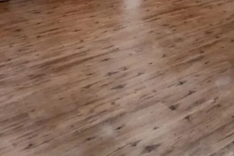 Finished wood laminate floor in open room with cabinets, C&A Roofing & Construction