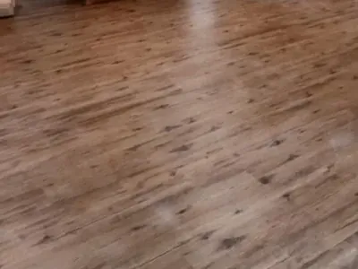Finished wood laminate floor in open room with cabinets, C&A Roofing & Construction