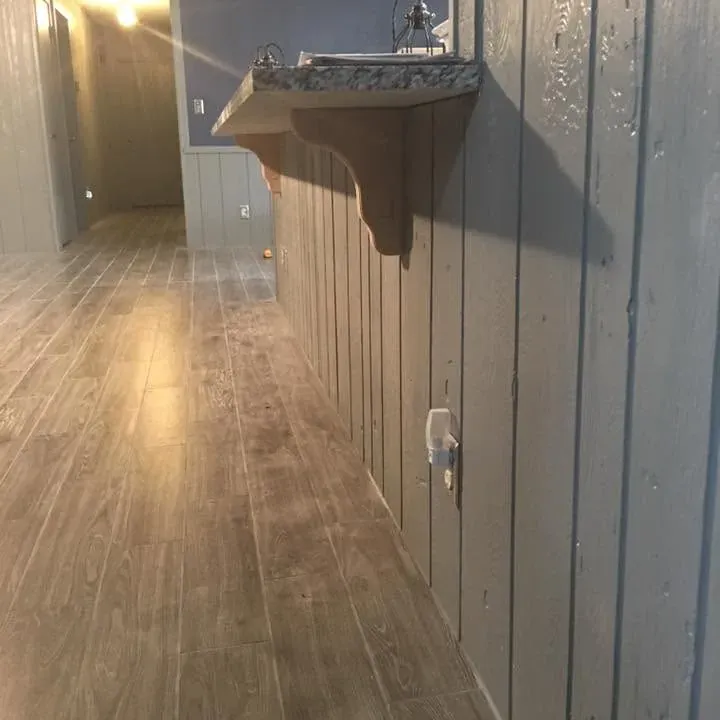 Hallway with gray laminate floor and painted gray paneling, C&A Roofing & Construction