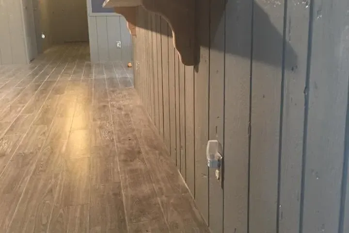 Hallway with gray laminate floor and painted gray paneling, C&A Roofing & Construction