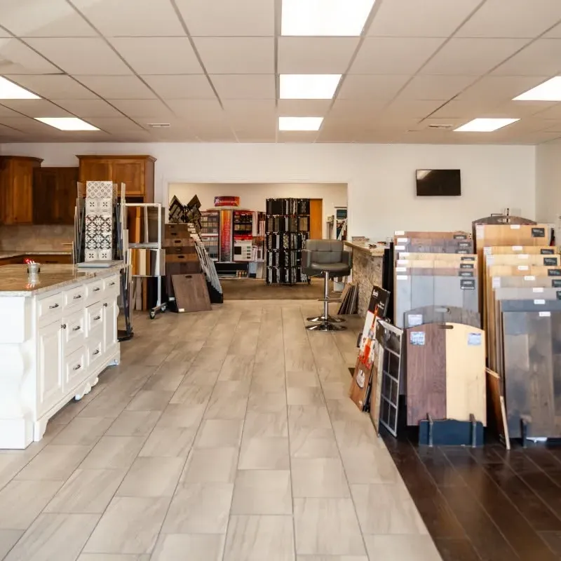 Wide showroom with cabinets, island display and flooring samples, C&A Roofing & Construction