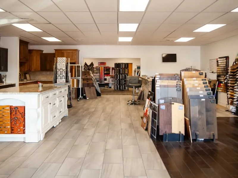 Wide showroom with cabinets, island display and flooring samples, C&A Roofing & Construction