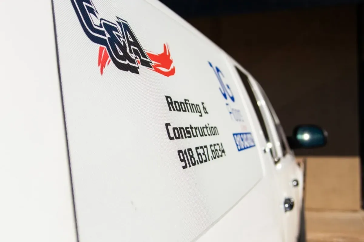 Close-up side of white truck with C&A logo and phone, C&A Roofing & Construction