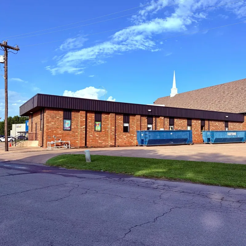 Brick church/commercial building with dumpsters, wide sky, C&A Roofing & Construction
