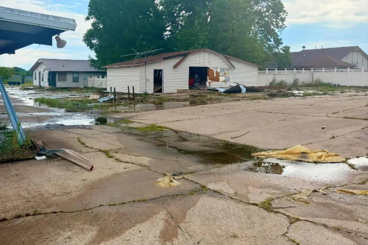 Cracked lot with standing water and damaged outbuilding, C&A Roofing & Construction