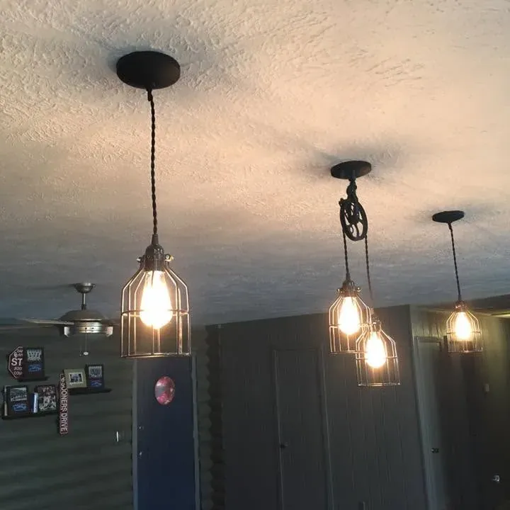 Three industrial cage pendant lights hanging from ceiling, C&A Roofing & Construction