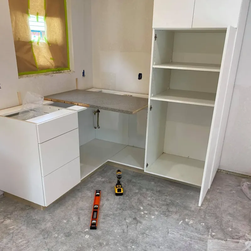 Unfinished white kitchen cabinets set on bare subfloor, C&A Roofing & Construction