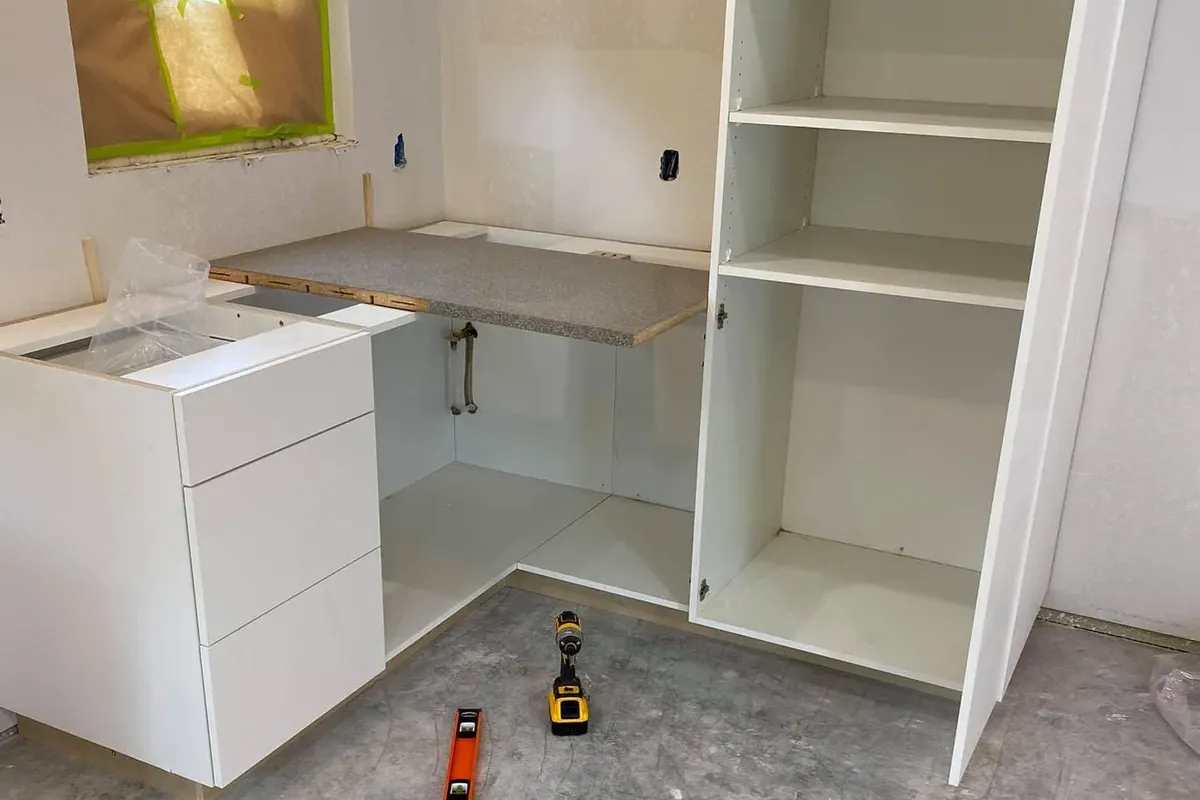 Unfinished white kitchen cabinets set on bare subfloor, C&A Roofing & Construction