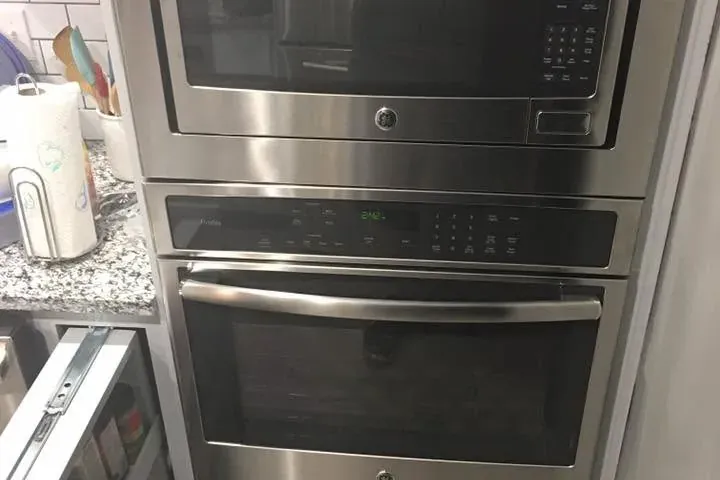 Stainless built-in wall oven and microwave in gray cabinetry, C&A Roofing & Construction