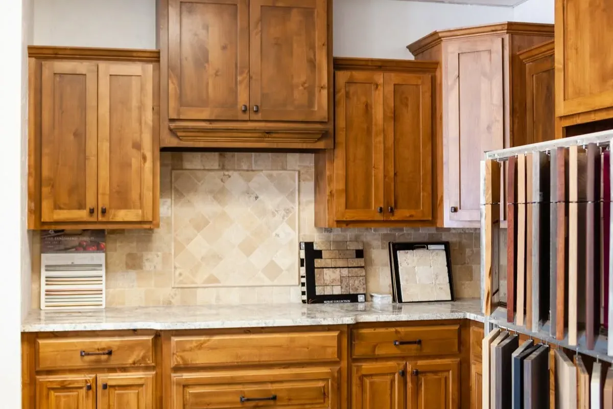 Showroom kitchen display with wood cabinets and tile backsplash, C&A Roofing & Construction