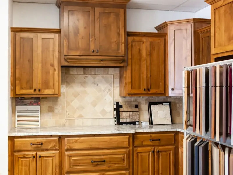 Showroom kitchen display with wood cabinets and tile backsplash, C&A Roofing & Construction