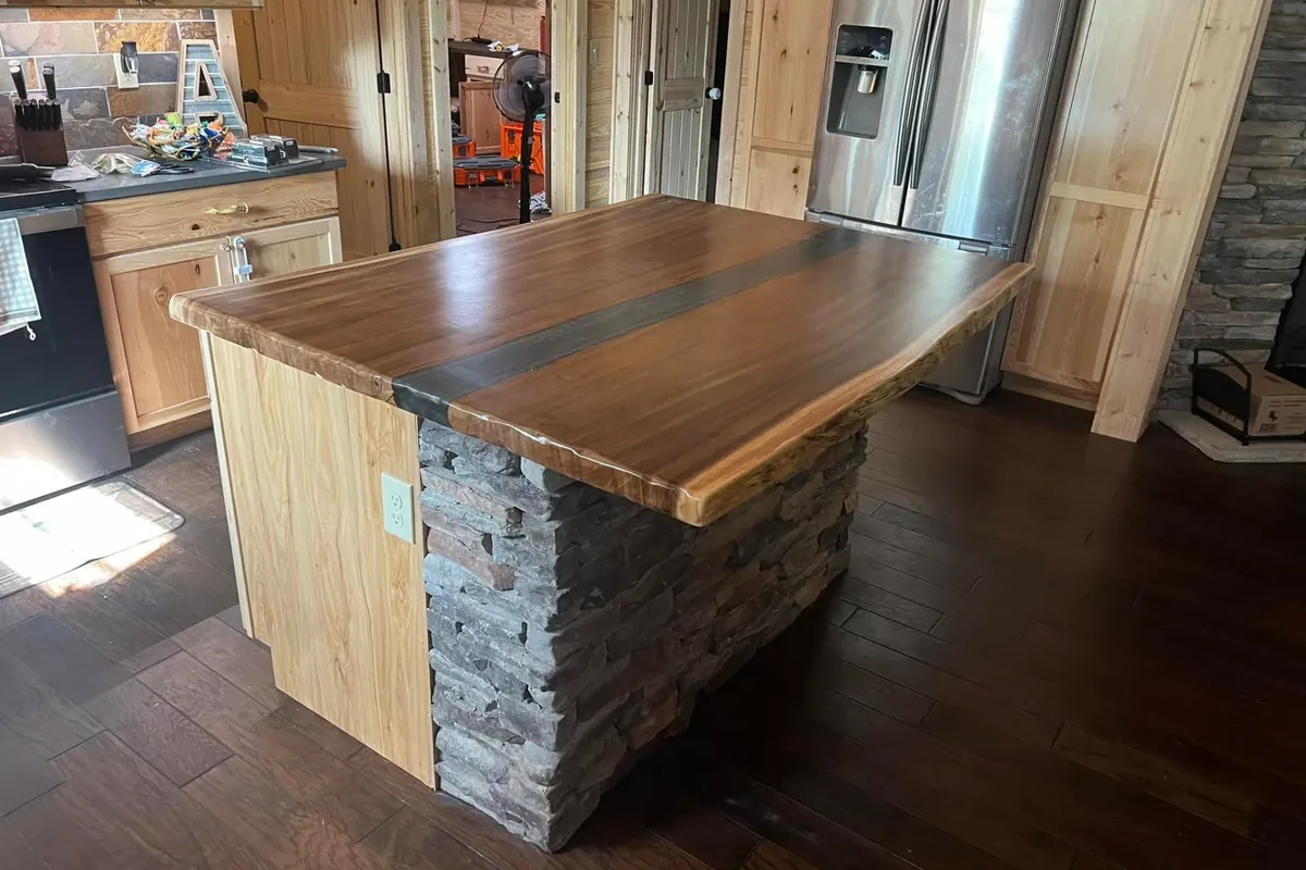 Custom island with live-edge wood top and stone base, C&A Roofing & Construction
