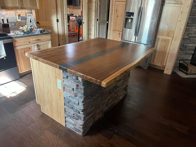 Custom island with live-edge wood top and stone base, C&A Roofing & Construction