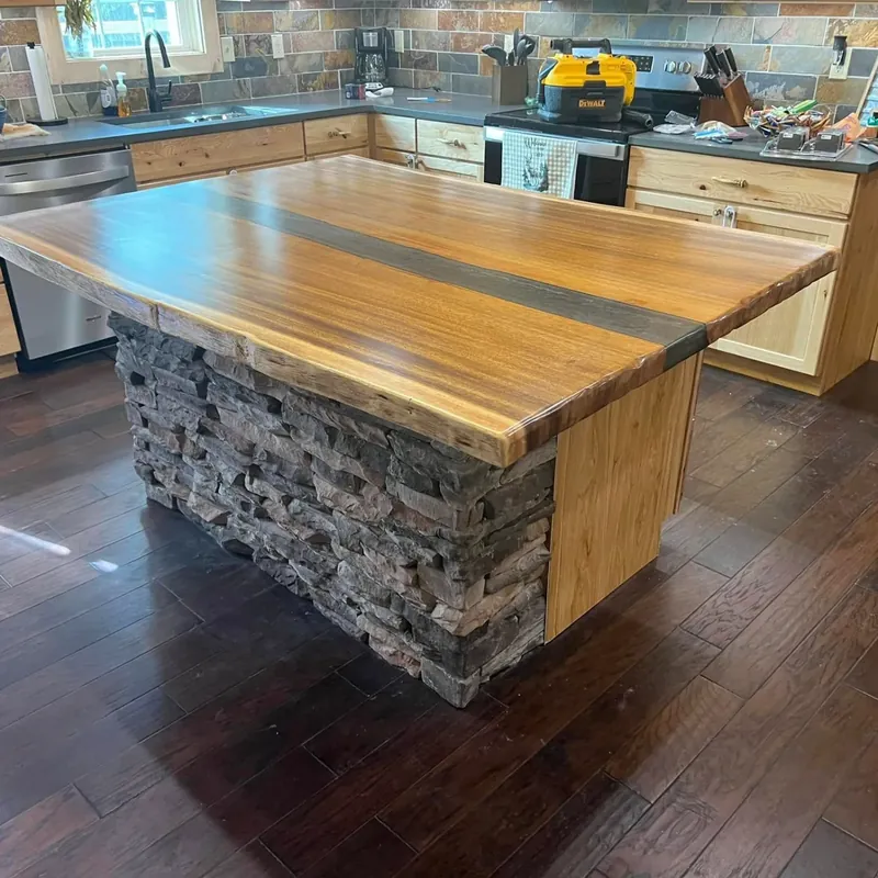 Live-edge wood island with stacked stone base, wider angle, C&A Roofing & Construction