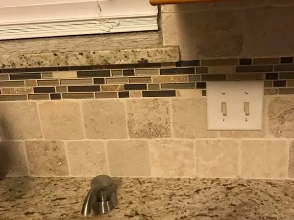 Granite countertop with tile mosaic backsplash close-up, C&A Roofing & Construction