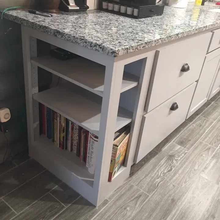 Granite-topped gray cabinets with bookshelf end, wood-look tile floor, C&A Roofing & Construction