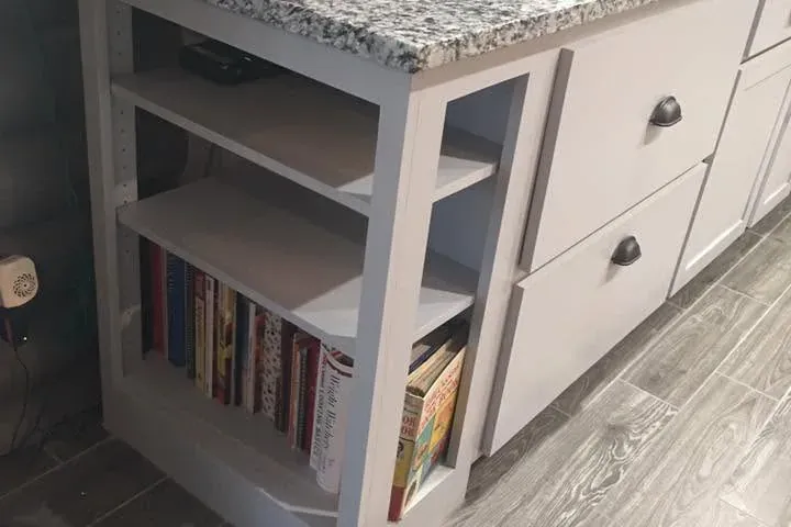 Granite-topped gray cabinets with bookshelf end, wood-look tile floor, C&A Roofing & Construction