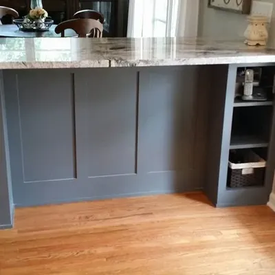 Gray paneled island with granite top on hardwood floor, C&A Roofing & Construction