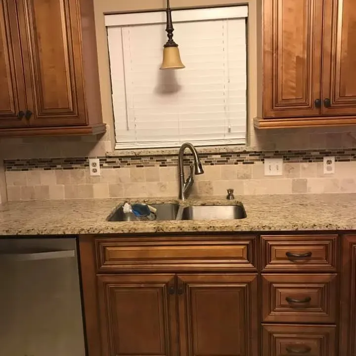 Wood cabinets, granite counter and sink under window, C&A Roofing & Construction