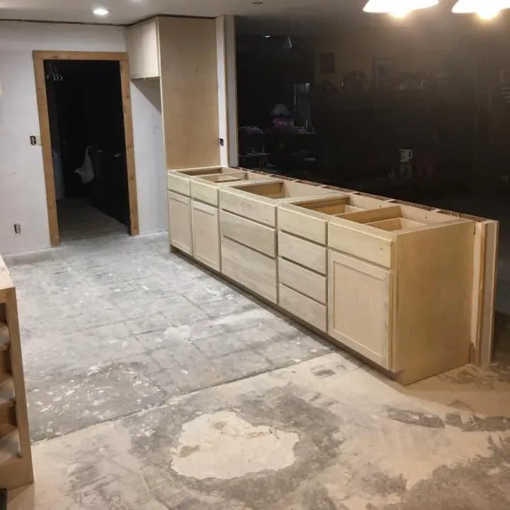 Row of new unfinished base cabinets in gutted kitchen, C&A Roofing & Construction