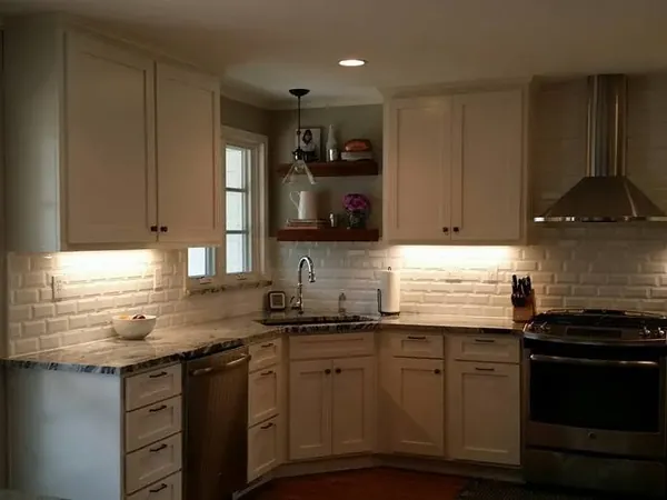 Finished white-cabinet kitchen with subway tile and range hood, C&A Roofing & Construction