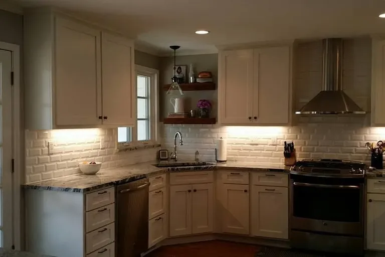 Finished white-cabinet kitchen with subway tile and range hood, C&A Roofing & Construction