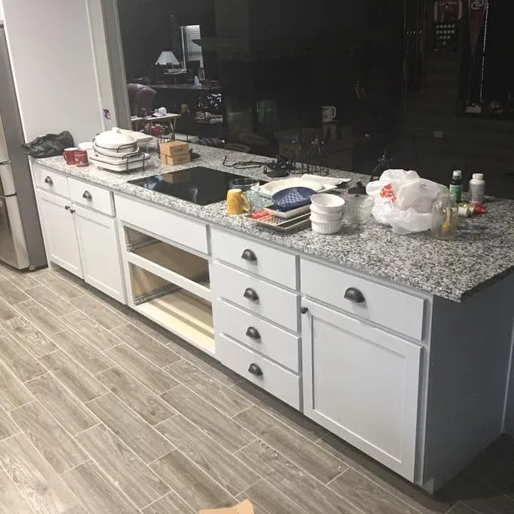 White cabinet island with granite top and stainless fridge, C&A Roofing & Construction
