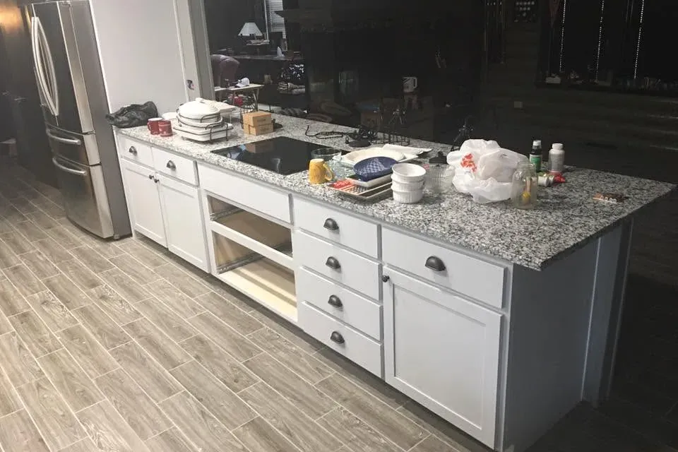 White cabinet island with granite top and stainless fridge, C&A Roofing & Construction